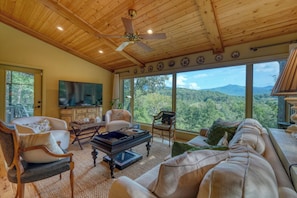 A spacious living room with a large television, comfortable seating, and a scenic mountain view. - The Cliff Retreat + mountain views + hot tub + 3 ensuite bedrooms + Brasstown fishing (Young Harris)