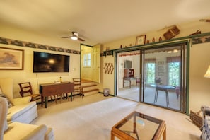 A living room with a TV, a dining area with a table and chairs, a sofa, and a glass door leading to a balcony. - The Cliff Retreat + mountain views + hot tub + 3 ensuite bedrooms + Brasstown fishing (Young Harris)