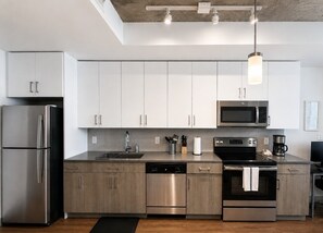 A modern kitchen with stainless steel appliances, white cabinets, and a wooden countertop. - Chic 2BR Near UAB & Dining 86 (Birmingham)
