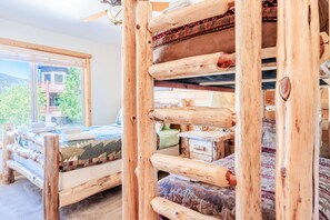 Een rustiek houten bed met uitzicht op een berg en een balkon.