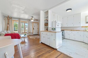A modern kitchen with white cabinets, a wooden countertop, and a built-in microwave. - Cute modern 2 bedroom cottage in Abilene, Texas (Abilene)