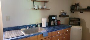 A kitchen with a sink, coffee maker, and a refrigerator. - Huntzinger Hideaway: Furnished 1 Bdrm apartment (Wernersville)