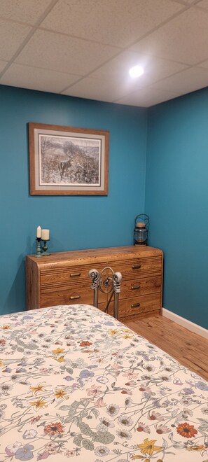A bedroom with a bed, dresser, framed picture, and a nightstand with a lamp. - Huntzinger Hideaway: Furnished 1 Bdrm apartment (Wernersville)