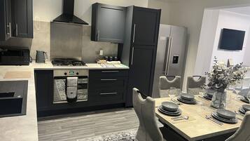 A modern kitchen with a built-in oven, microwave, and gas stove.