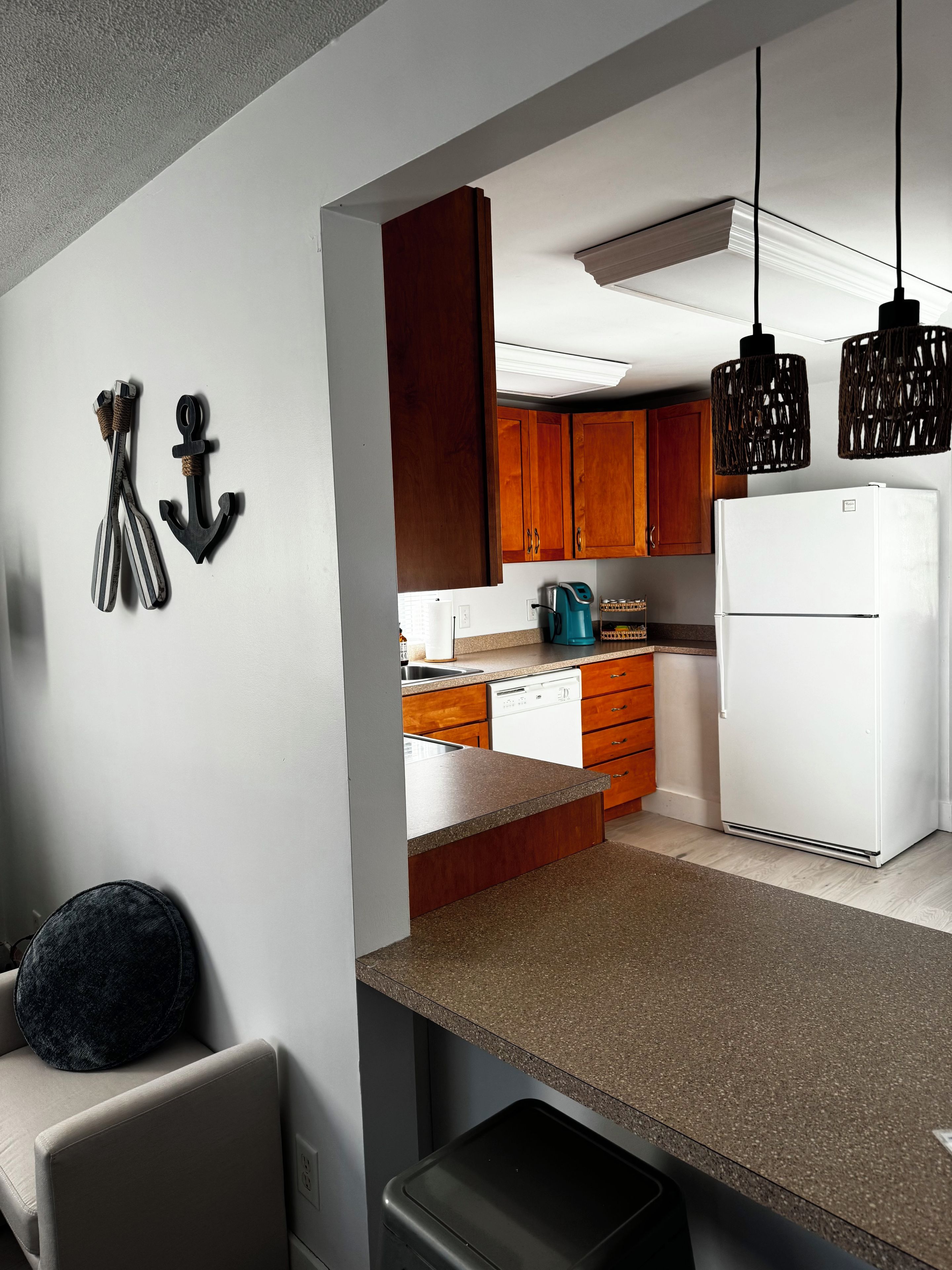 A modern kitchen with wooden cabinets, a white refrigerator, and a countertop.