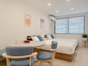 A modern bedroom with a bed, a round table, and two chairs. - New Opening Campaign Now Underway! Just a 1-minute walk to Dotonbori and a 2-minute walk to Nipponbashi Station. Conveniently located near Kuromon Market, Namba, and Shinsaibashi. With the bus stop for Kansai International Airport just a 1-minute walk awa (大阪市中央区道頓堀１丁目東)