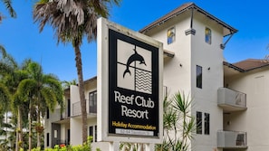 A sign for Reef Club Resort, indicating it is a holiday accommodation. - Ground-Floor One-Bedroom Port Douglas Stay with Shared Pool (Port Douglas)