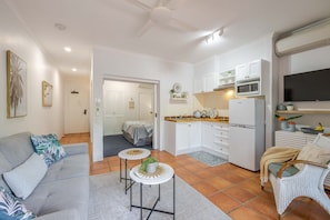 A compact living space with a kitchenette, a dining area, and a bedroom. - Ground-Floor One-Bedroom Port Douglas Stay with Shared Pool (Port Douglas)