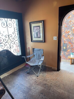 A room with a chair, a framed picture on the wall, and a patterned wall. - Peaceful 1-bedroom condo in enchanting B.C. perfect for relaxing (B.C.)