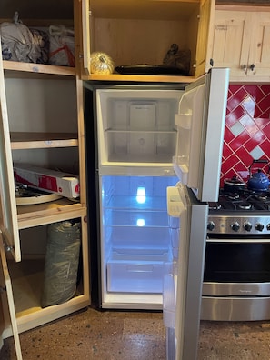 A kitchen with a built-in refrigerator, a stove, and a red tiled backsplash. - Peaceful 1-bedroom condo in enchanting B.C. perfect for relaxing (B.C.)