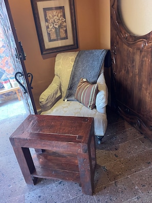 A wooden table in a room with patterned upholstery and a framed picture on the wall. - Peaceful 1-bedroom condo in enchanting B.C. perfect for relaxing (B.C.)