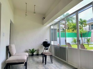A sunlit room with a grill, seating, and potted plants. - Lomas Cocoyoc Private pool / barbecue / Wi-Fi / pet-friendly (Fraccionamiento Lomas de Cocoyoc)