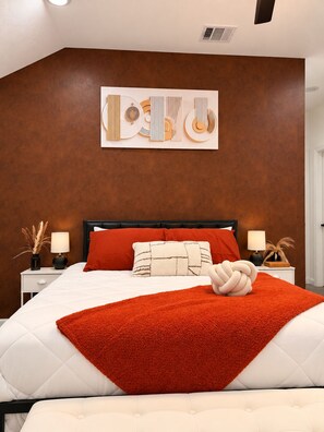 A modern bedroom with a large bed, a unique wall art piece, and a decorative knot on the bed. - Modern 3BR Houston Escape in the Heart of HTX (Houston)