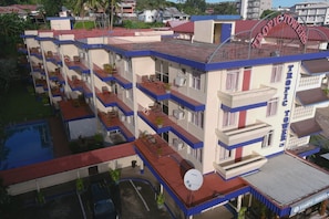 A multi-story hotel with balconies, a swimming pool, and a satellite dish. - Tropic Towers Apartments Hotel (Suva)