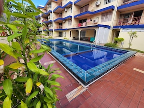 A swimming pool with a tiled edge, surrounded by a red-tiled patio. - Tropic Towers Apartments Hotel (Suva)