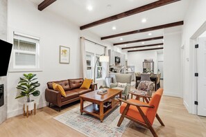 A modern living room with a brown leather sofa, a wooden coffee table, and a patterned rug. - Spacious 5BR Tacoma Home - Sleeps 9 - Hilltop -Fenced Yard + Playroom (Tacoma)