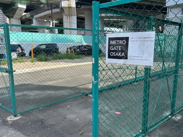 A green metal fence with a sign indicating 'METRO GATE OSAKA' and a map. - METRO GATE OSAKA (Osaka)