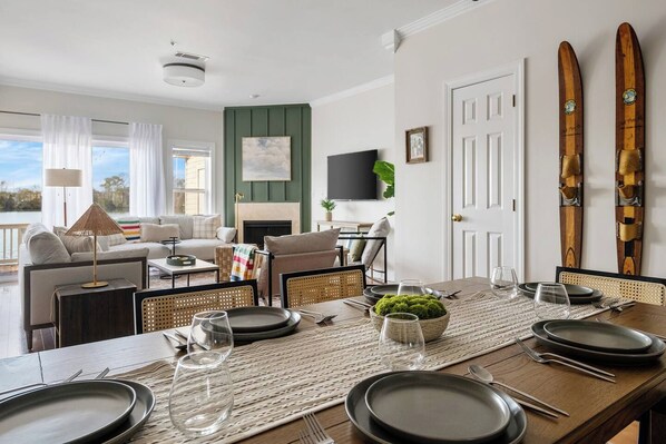 A dining area with a long table set for four, a fireplace, and a view of the outdoors. - 1 & 2 Lowcountry Lakehouse: Child & Pet Friendly! (North Charleston)
