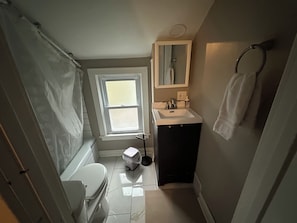 Une petite salle de bain comprenant des toilettes, un lavabo et une fenêtre.