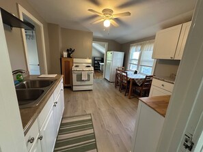 A compact kitchen with a stove, sink, and refrigerator, wooden cabinets, and a ceiling fan. - 2-Bedroom Upper Unit Duplex on Quiet Street in Roseville (Roseville)