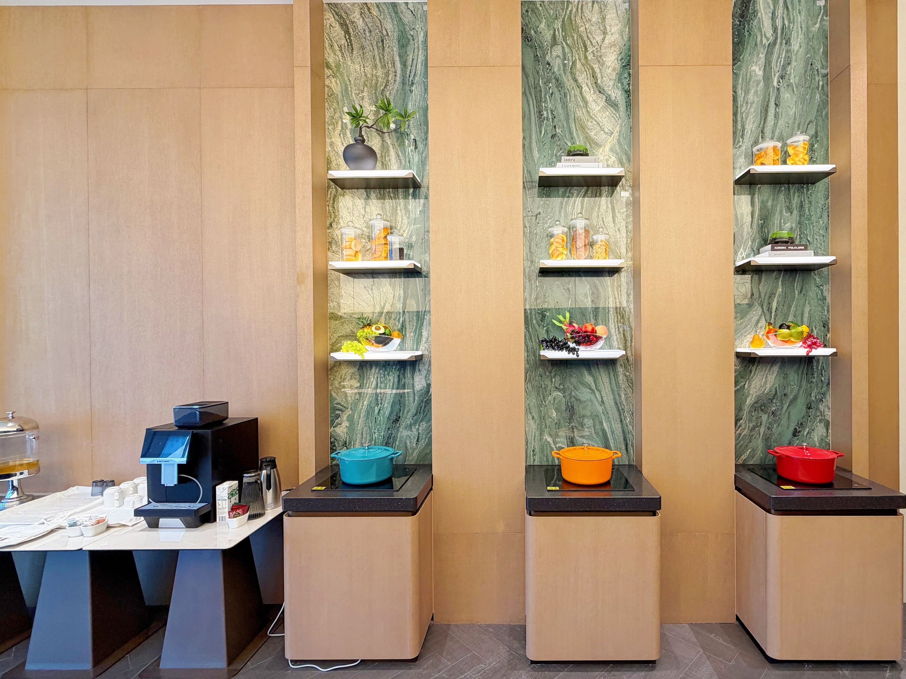 A kitchen area with built-in shelves displaying various food items and kitchen appliances.