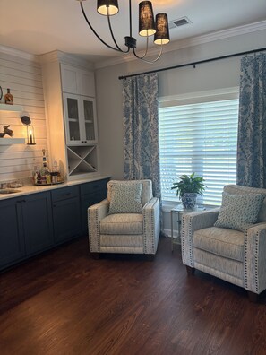 A modern kitchen with dark cabinetry, a white countertop, and a pendant light fixture. - Private 50-Acre Executive Retreat in Sumter, SC 12 Min to Courthouse (Sumter)