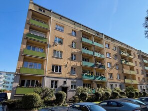 A multi-story residential building with balconies, a flat facade, and a parking area in front. - Dworcowa Old Town Studio (Wrocław)