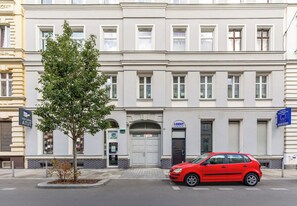 Eine Reihe mehrstöckiger Gebäude mit einem roten Auto davor.