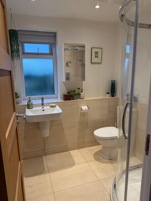 A bathroom with a sink, toilet, and a glass shower enclosure.