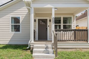 A two-story house with a front porch, a dark front door, and a mailbox. - Downtown Retreat Wi-Fi Unrestricted Parking (Indianapolis)