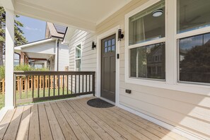 A wooden deck with a door and windows, a small porch area, and a visible garage door. - Downtown Retreat Wi-Fi Unrestricted Parking (Indianapolis)