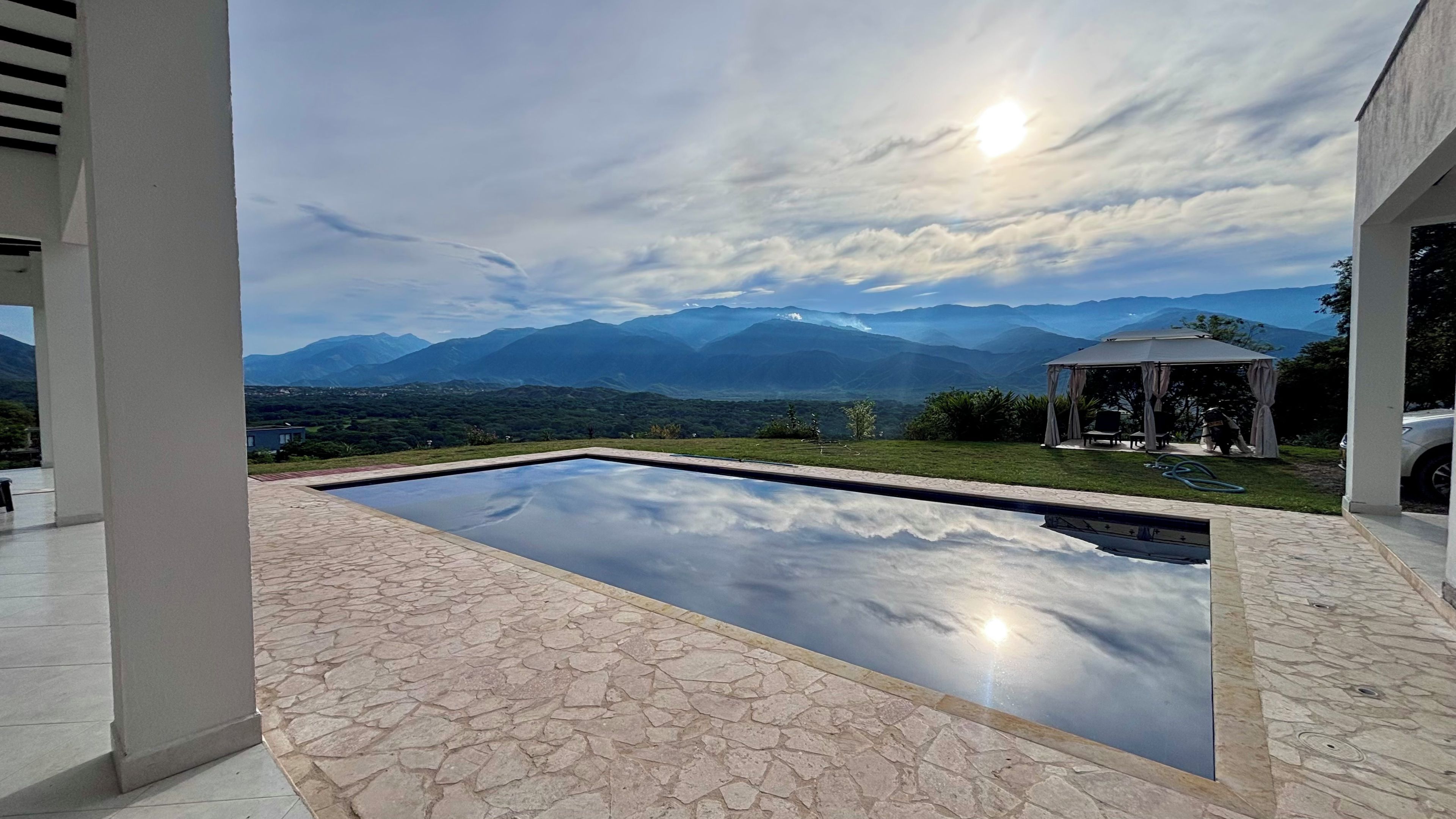 Una piscina con vista sulle montagne e un gazebo.