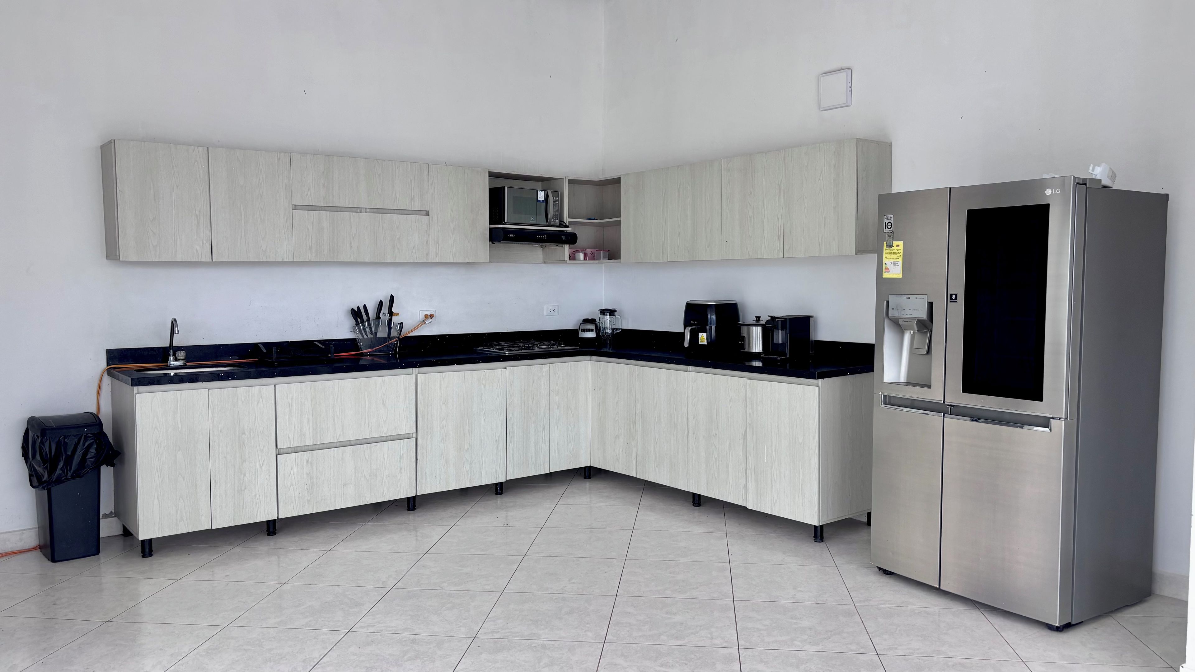 A modern kitchen with a stainless steel refrigerator, a microwave, and a coffee maker.