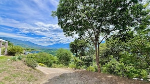 Paisaje rural con cielo despejado, un sendero de grava y vistas a montañas distantes.
