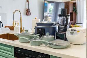 Una cocina con lavavajillas Bosch, olla de cocción lenta Ninja y cocedor de arroz Tiger sobre la encimera.