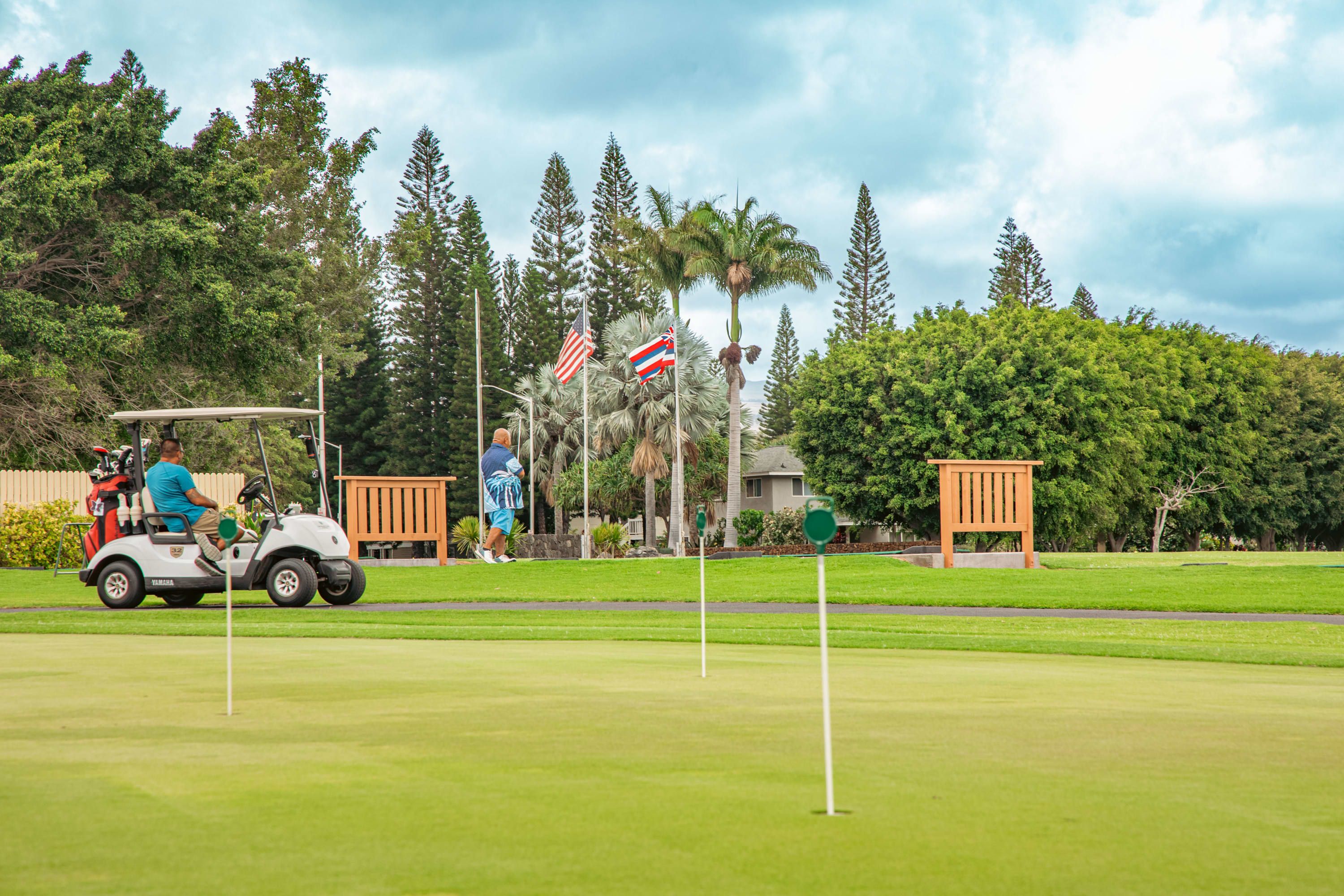 Un parcours de golf équipé de voiturettes, de drapeaux et de structures en bois.
