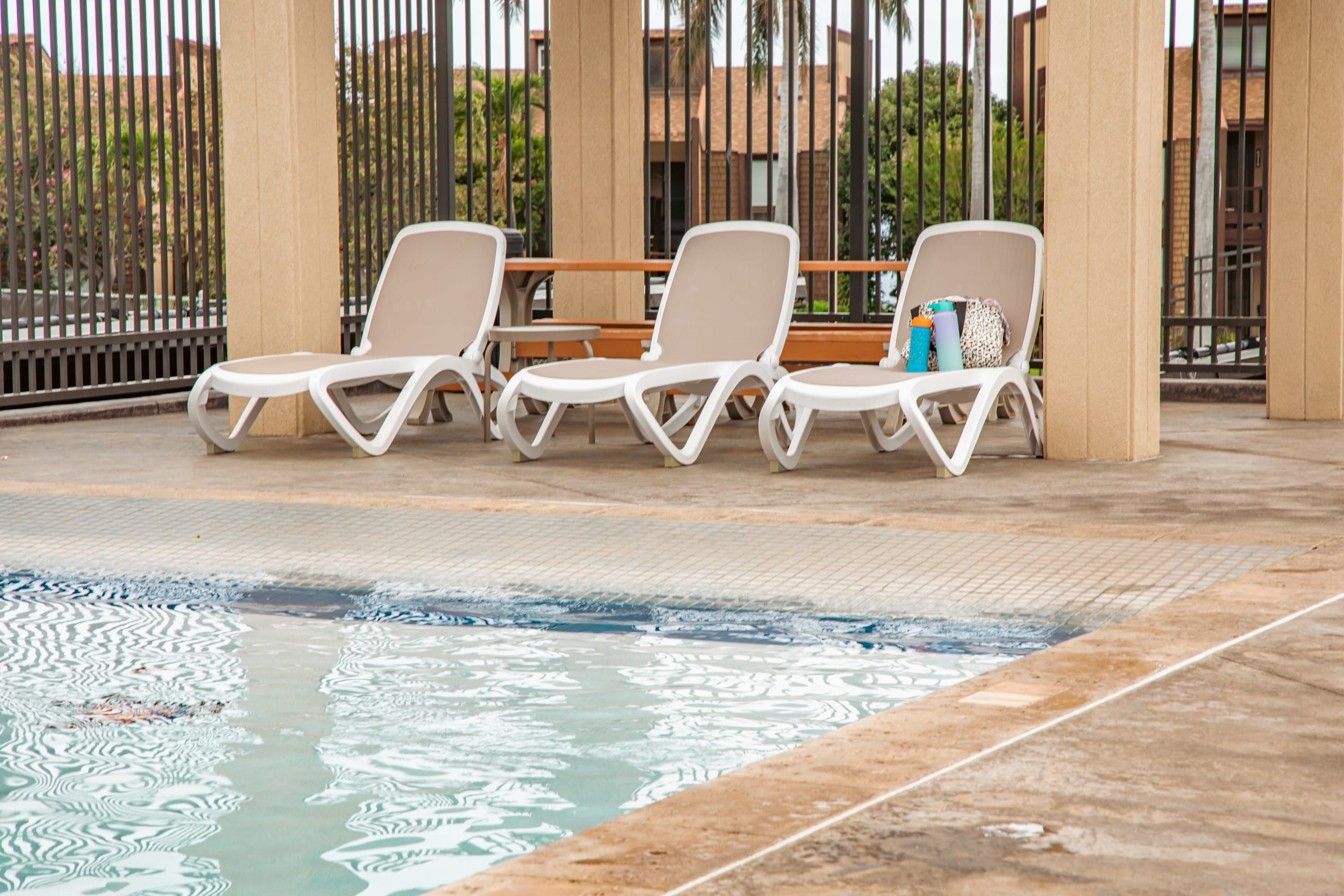 A poolside area with lounge chairs and a pool.