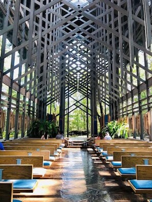 A church interior with rows of pews and a central aisle leading to a raised platform. - Eureka Springs Lake Lodge sleeps 14 - Hot Tub (Eureka Springs)