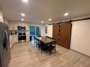 Una cocina moderna con una mesa de comedor, armarios y una puerta corredera.