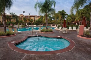 A pool area with a hot tub, lounge chairs, and palm trees. - Orlando | Pool & Disney Access | 3BR Sleeps 10 (Lake Buena Vista)