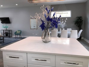 A modern dining area with a white table, chairs, and a vase with blue flowers. - Stylish Grant Park Home Minutes from Downtown Atlanta perfect for your getaway (Atlanta)