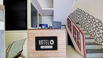 Mostrador de recepción de hotel con un cartel que indica que es administrado por OYO.