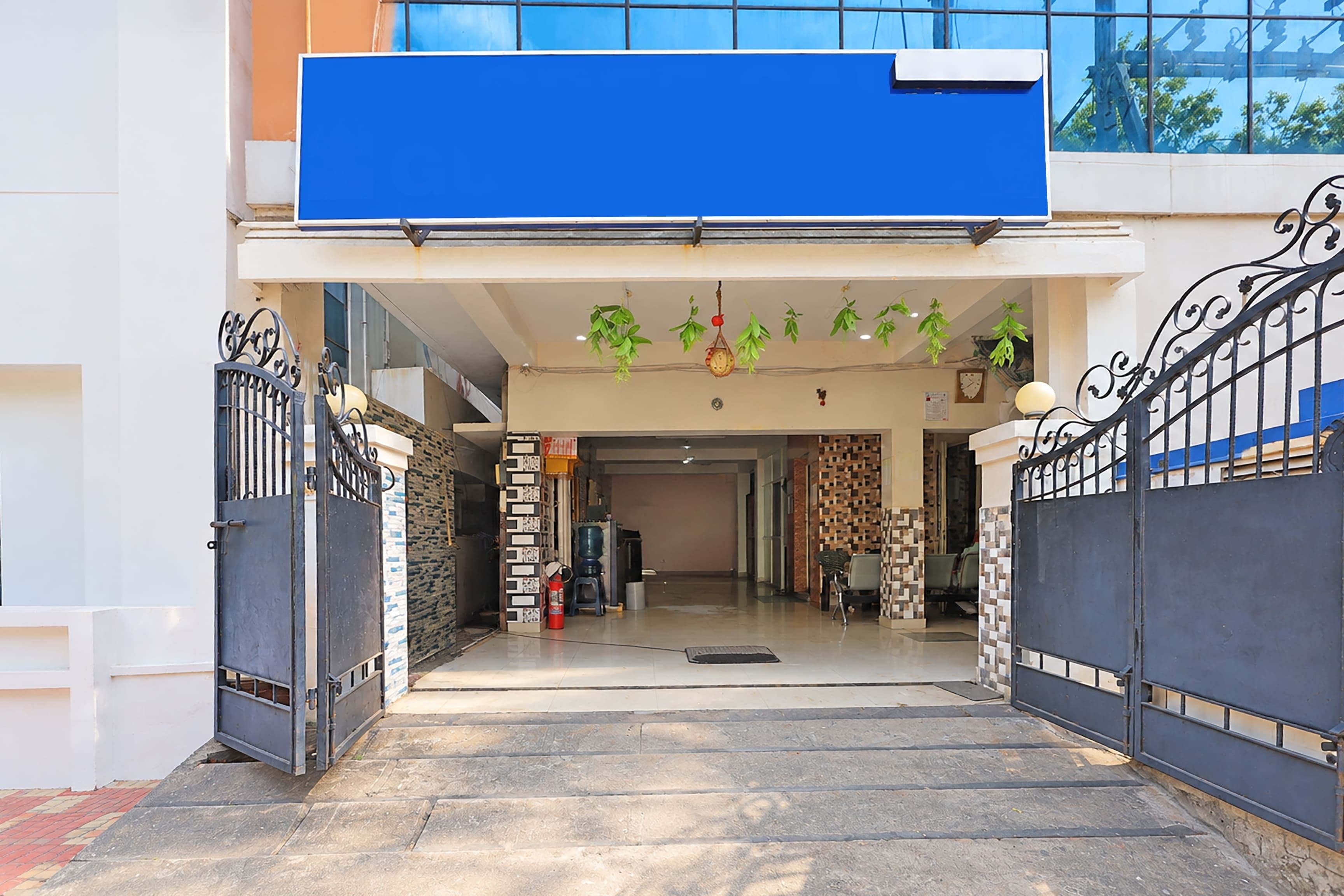 A building entrance with a blue awning, a staircase leading to the entrance, and a fire extinguisher near the door.
