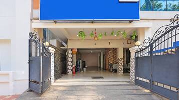 A building entrance with a blue awning, a staircase leading to the entrance, and a fire extinguisher near the door.