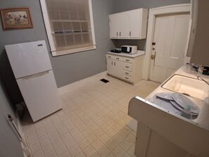 Eine kleine Küche mit Kühlschrank, Mikrowelle und Spüle.
