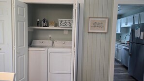 Une buanderie équipée de deux machines à laver LG, d’un étendoir et d’un panier à linge.
