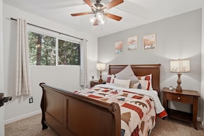 A bedroom with a wooden bed, two bedside tables with lamps, a ceiling fan, and a window with curtains. - La Cabaña. A Redwood Retreat with Hot Tub & Starry Nights (Pioneer)