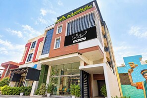 A modern building with a storefront labeled 'Collection' and a mural of a hand holding flowers. - Collection O BapatSquareFormerly Riboila (Indore)