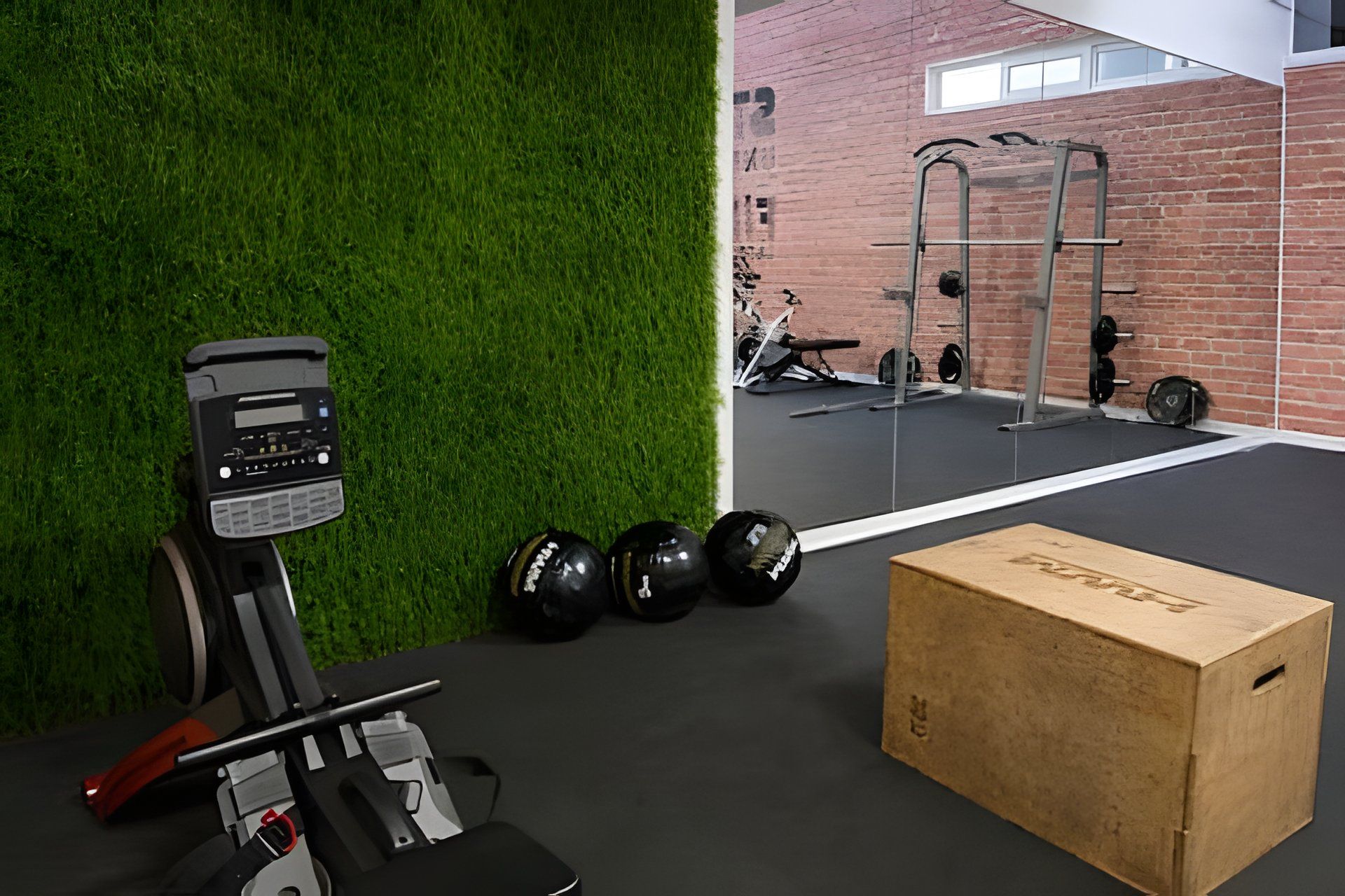 A gym with exercise equipment, a green wall, and a brick wall in the background.