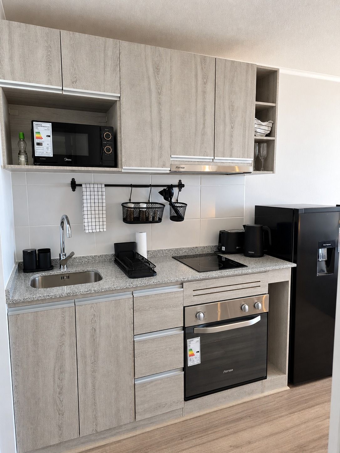 Una cocina moderna equipada con microondas, horno y refrigerador.